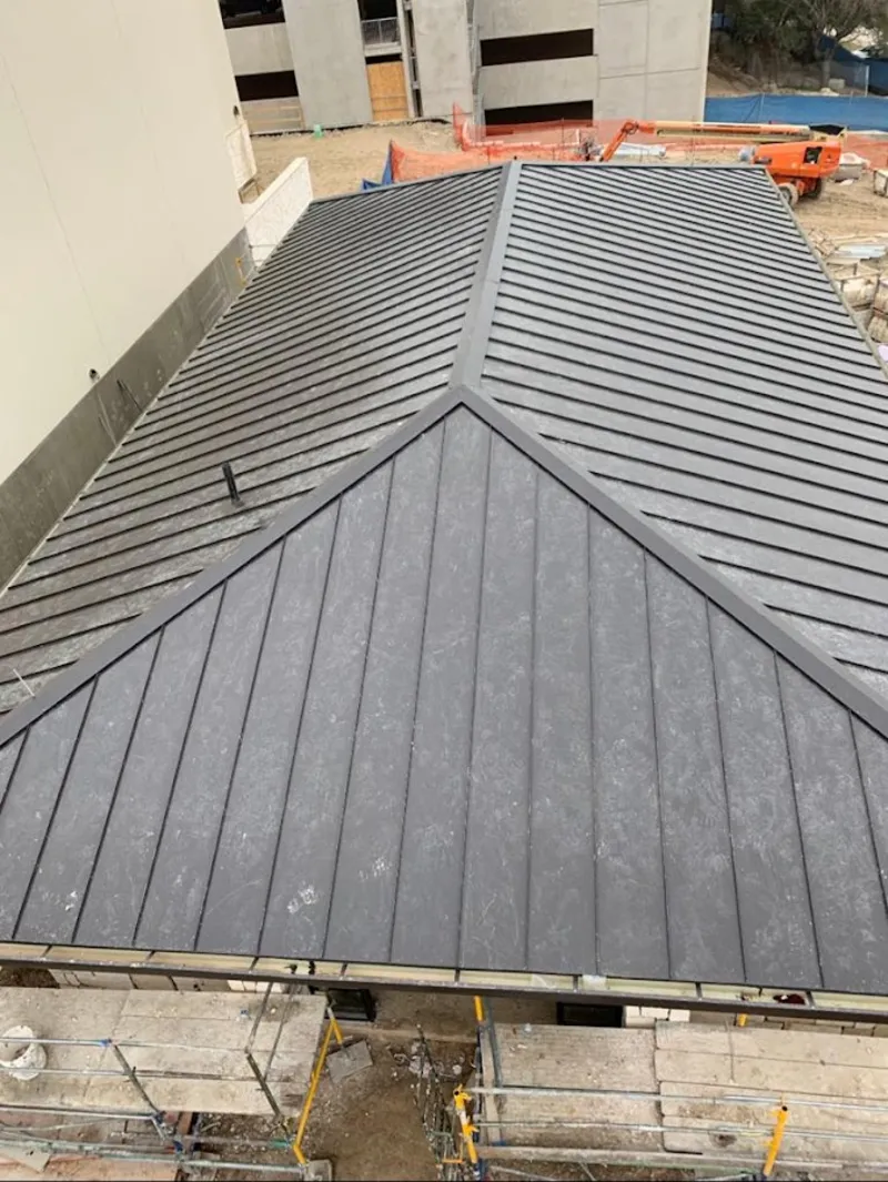 Commercial metal roof construction with crane equipment in St. Johns